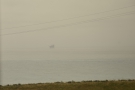 The oil rigs are still out there, partially obscured by the mist.