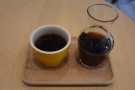 ... served in a carafe and presented on a tray, with a handleless cup on the side.