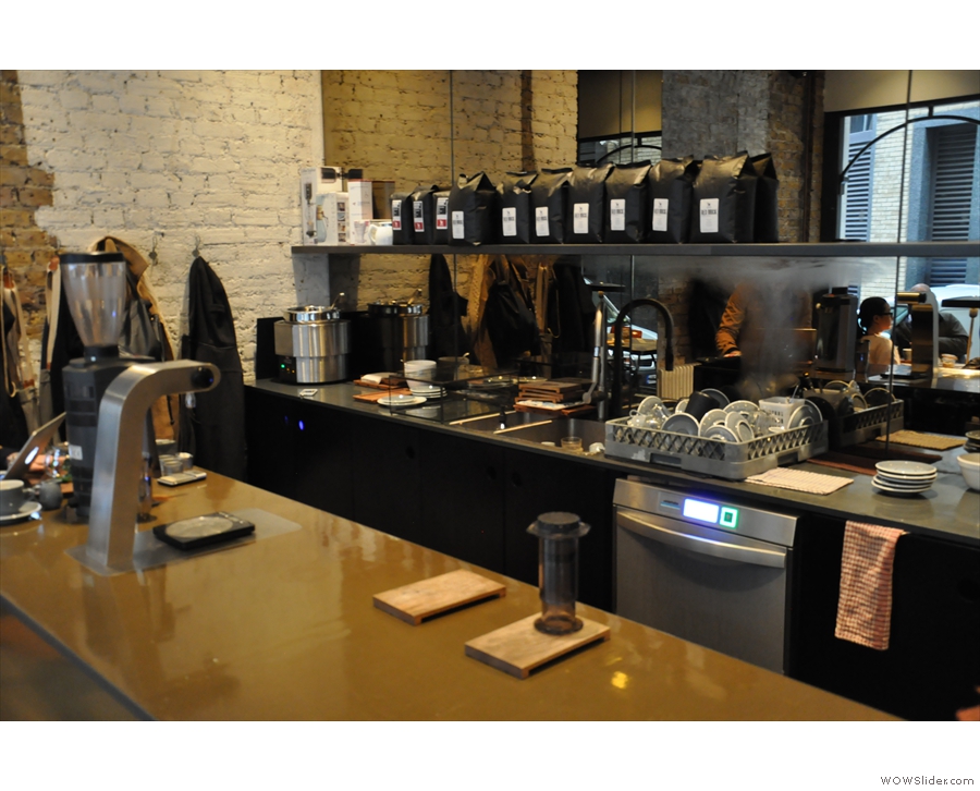 The counter is sparsely populated. The brew bar, with its own grinder, is at the far end.