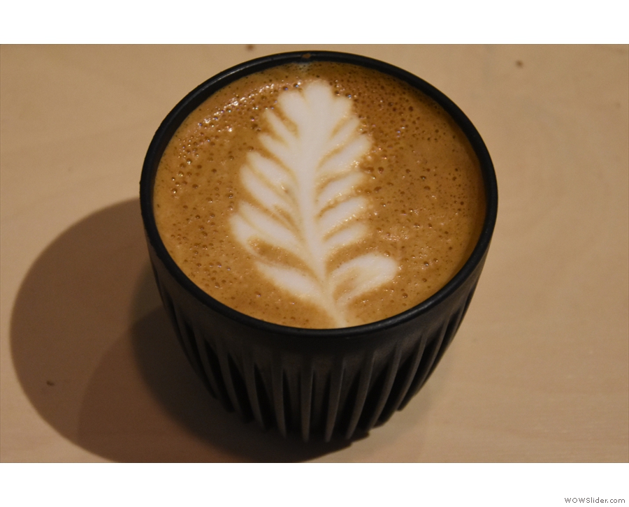 It's still open and serving: here's a flat white I had just before Christmas.