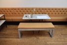 After the long, communal table, a series of smaller, four-person tables run along...