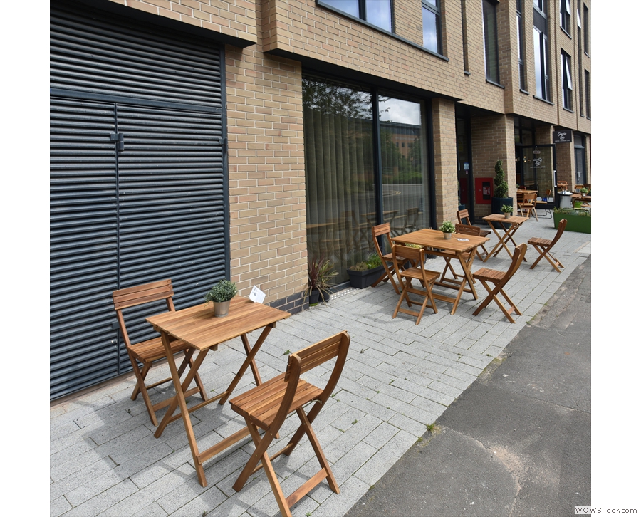 The tables extend a long way down the pavement, far beyond the front of the cafe.