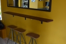 Matching that are three more stools at a narrow bar under a mirror.