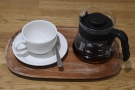 The coffee is served in the carafe, presented on a tray with a proper cup.