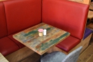 In all, there are three two-person tables running along this red, padded sofa-bench.