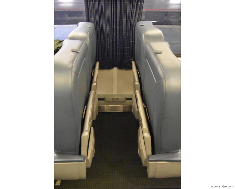 There's additional luggage space between sets of table seats (note the seat-back tables!).