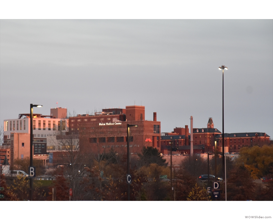 Looking east, Maine Medical Center is lit up by the setting sun.