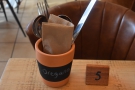 Each table has a number, while each of the little pots with the cutlery...