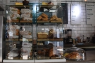 The cakes and bagels are displayed in glass cases on the left-hand end of the counter...