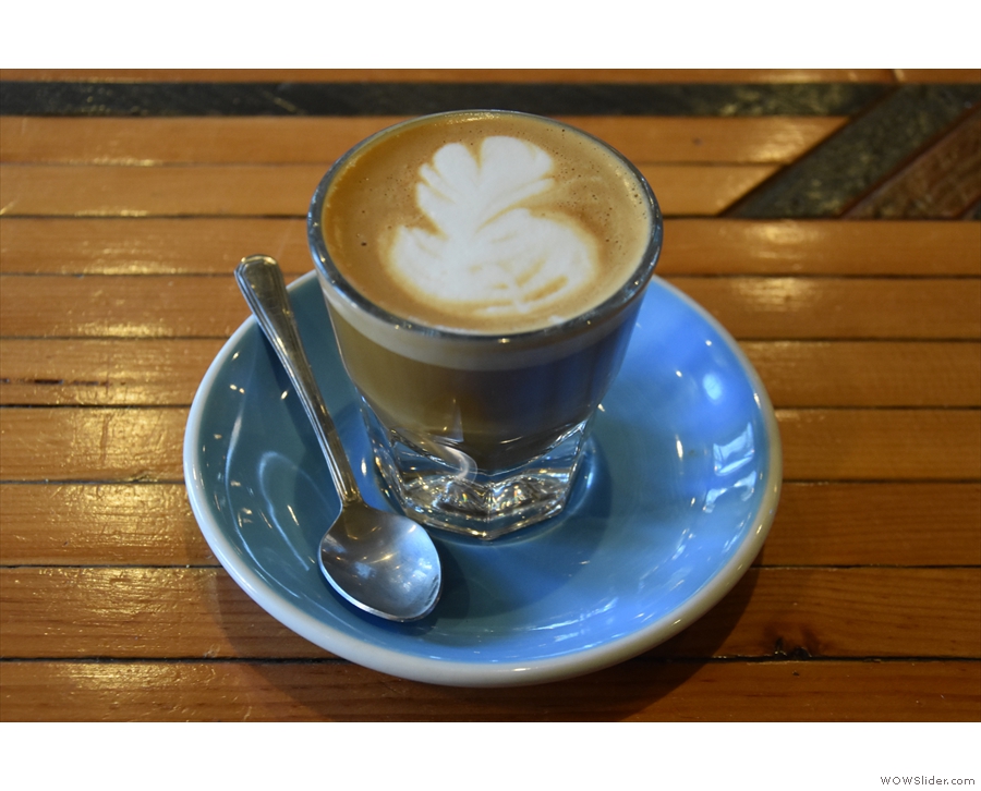 ... along with an excellent cortado, served in a glass on a blue saucer.
