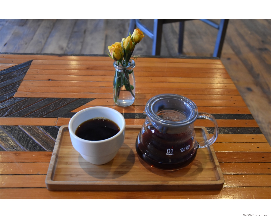 My coffee, in the carafe, with a cup on the side, all presented on a neat wooden tray.