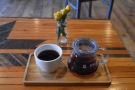 My coffee, in the carafe, with a cup on the side, all presented on a neat wooden tray.