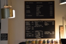 The coffee and drinks menus are on the wall behind the counter.