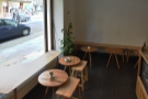 The seating starts to the left of the door with a window-bench and two tables...