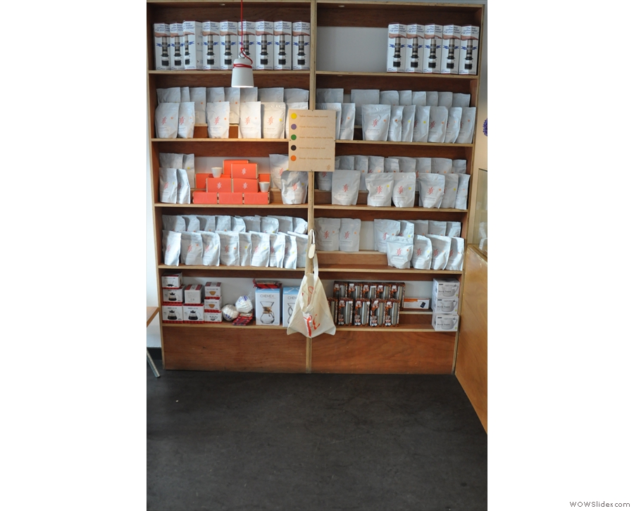 There's this set of shelves to the left of the counter, full of beans and coffee kit.