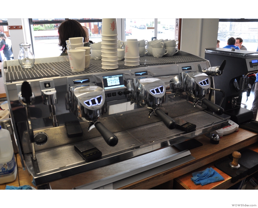 A behind-the-scenes view of the Black Eagle, with a Nuova Simonelli grinder to the right.