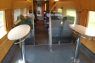 ... in first class configuration, followed by a standing area with four of these oval tables...