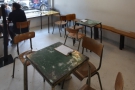 There's a solitary table in the middle of the room, with two more tables in the window to...
