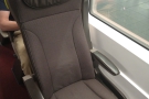 My seat, a solo airline-style seat on the left, facing in the direction of travel.