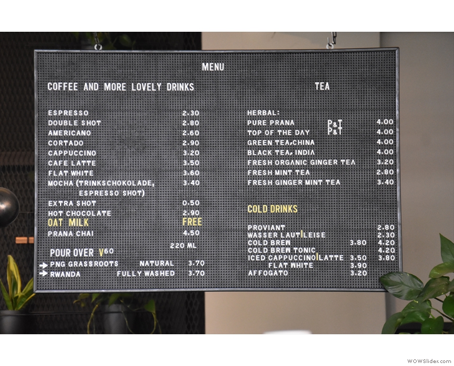 The drinks menu hangs down behind the till, coffee on the left, other drinks to the right.