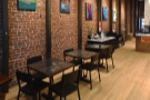 ... followed by three two-person tables along the exposed brick of the left-hand wall.