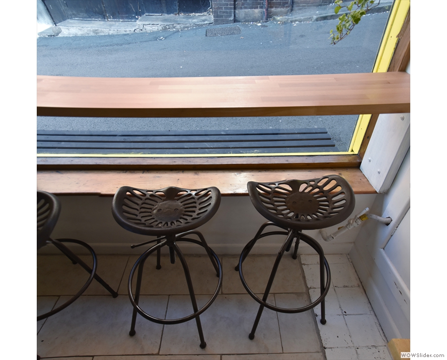 The window-bar runs the full length of the window with four of these backless chairs.