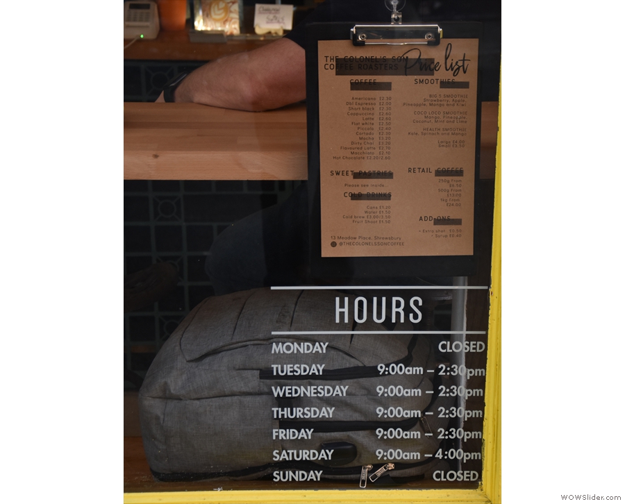The opening hours and menu are on display by the door.