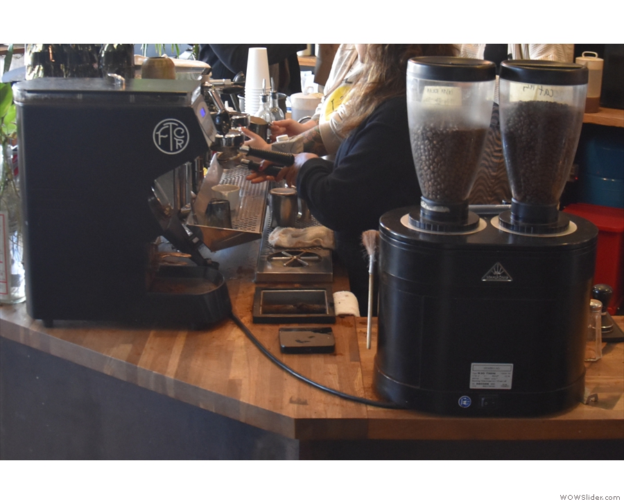 ... two-group Mirage espresso machine which sits on the corner with its three grinders.