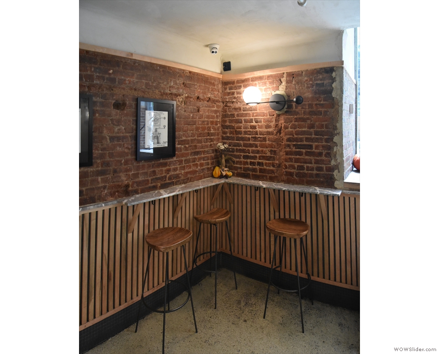 The interior seating consists of just three tall stools at this L-shaped bar to the right...
