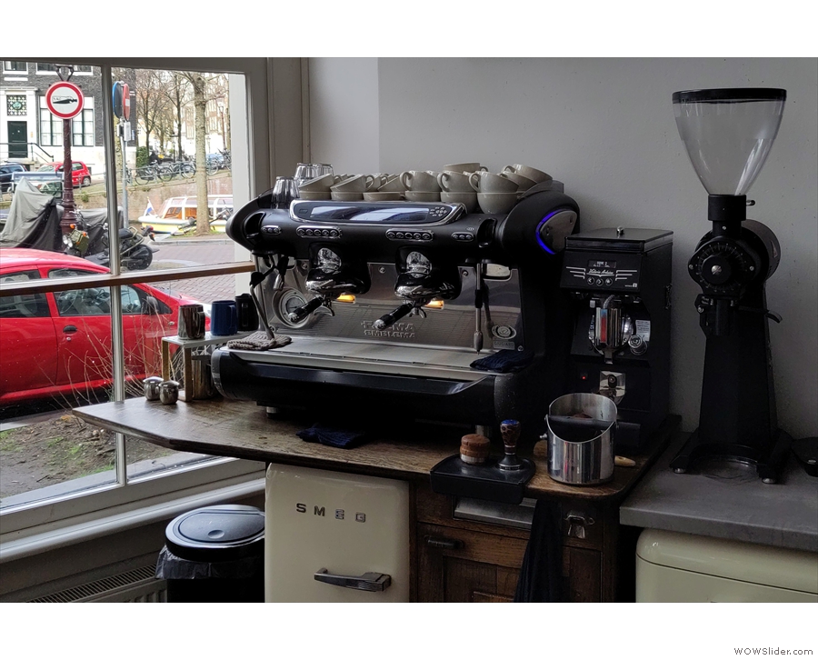 Unusually, the espresso machine is off to the left of the counter, in the front window...