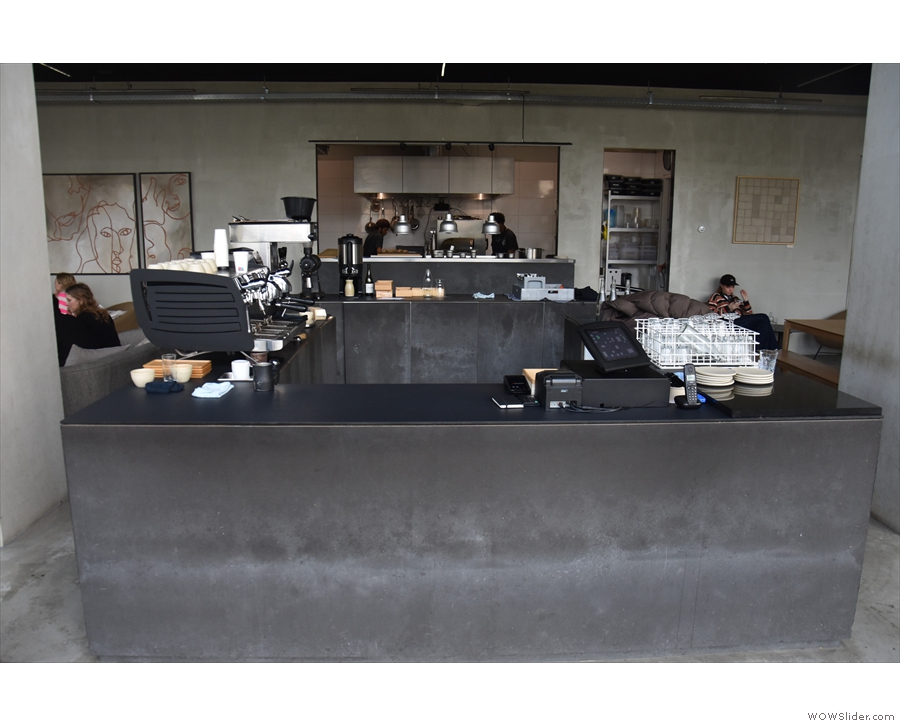 Stepping inside, you're greeted by this concrete counter, the kitchen...