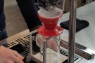 The barista places the ground coffee in the filter paper/V60, puts it on the stand and...