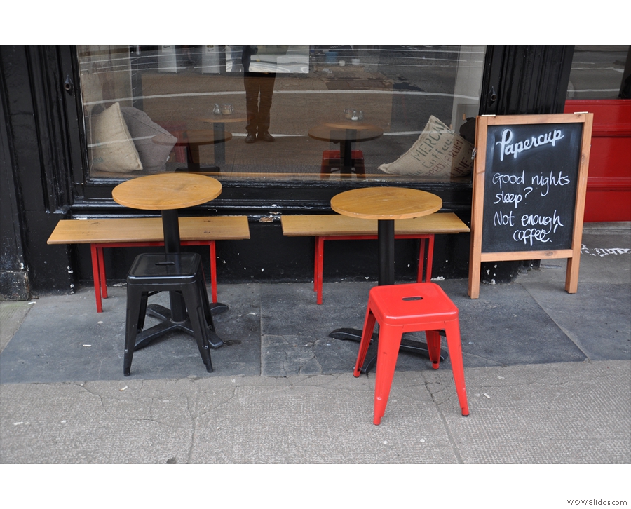 There's a couple of small tables with benches/stools on the pavement outside.