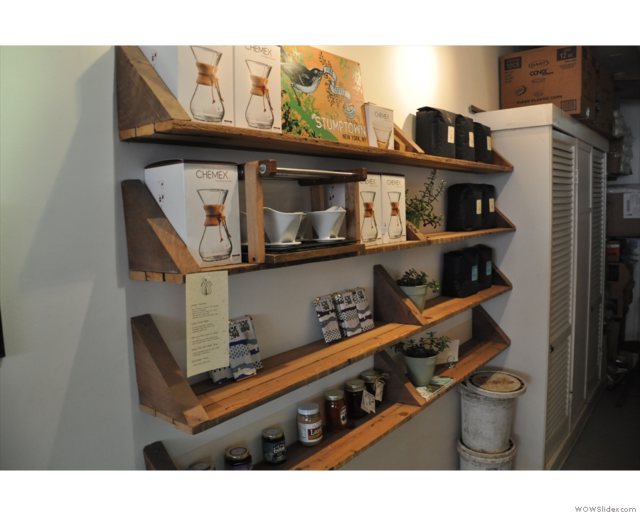 Shelves of coffee and coffee-making kit for sale at the back.