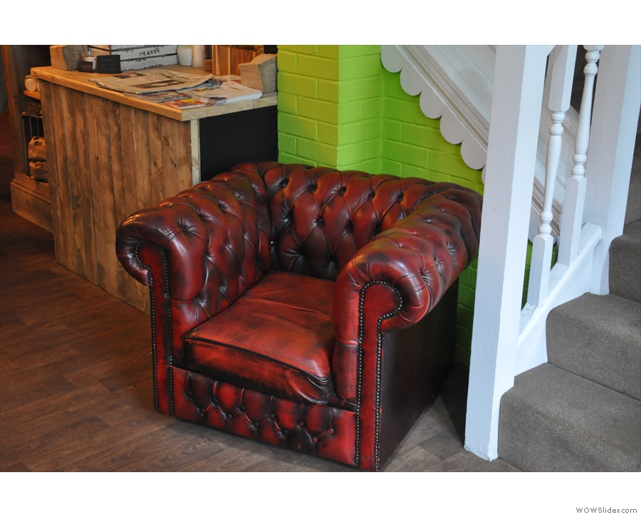 ... while its matching armchair is tucked away by the stairs on the opposite side.