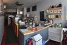 A panoramic view from just inside the door. The front is dominated by the counter...