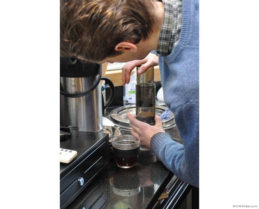 Once the timer goes off, Adam presses down on the Aeropress to complete the extraction.