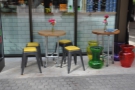 Some more of outdoor seating: a pair of tables (on wheels) to the right of the door.