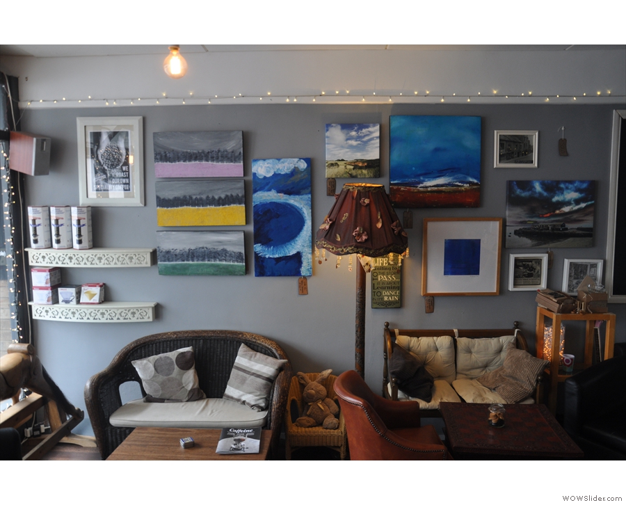 Both walls are adorned with an eclectic range of works of art, including paintings & photos.