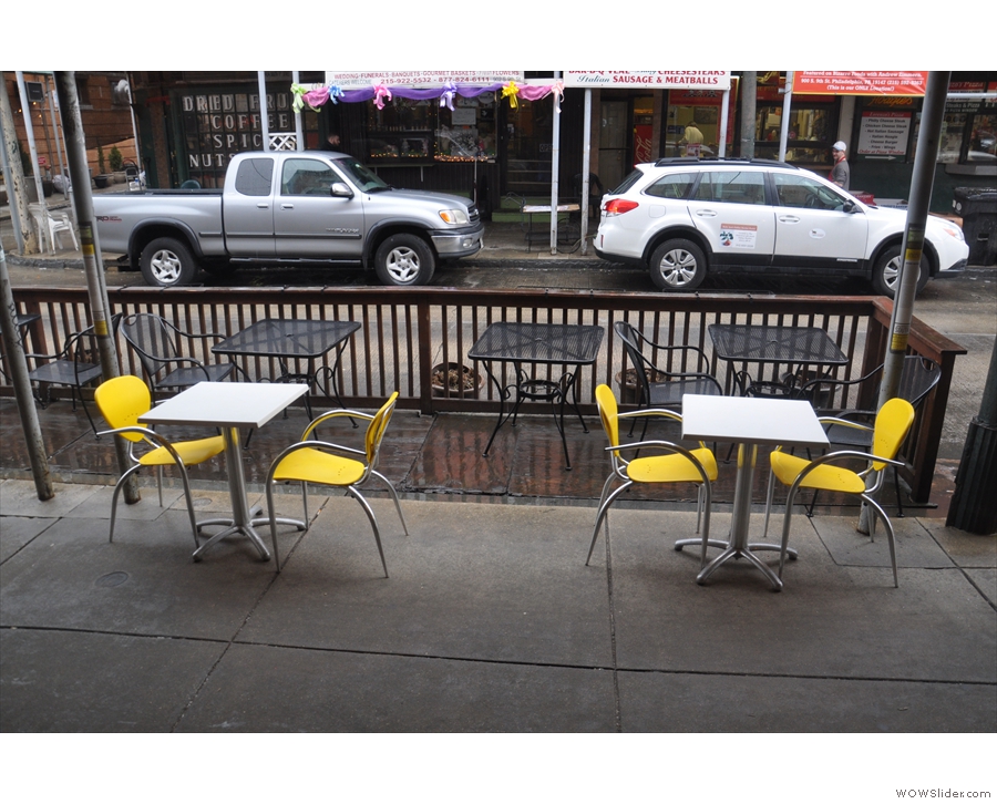 The two tables on the sidewalk are sheltered from the rain. The rest, however, are not...