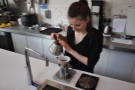 After putting the coffee into the Kalita Wave filter, she adds hot water.