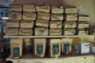 One wall of the connecting corridor is lined with shelves, stuffed with bags of coffee...