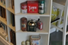 The counter is full of little bits and pieces like these shelves with their little coffee grinder.